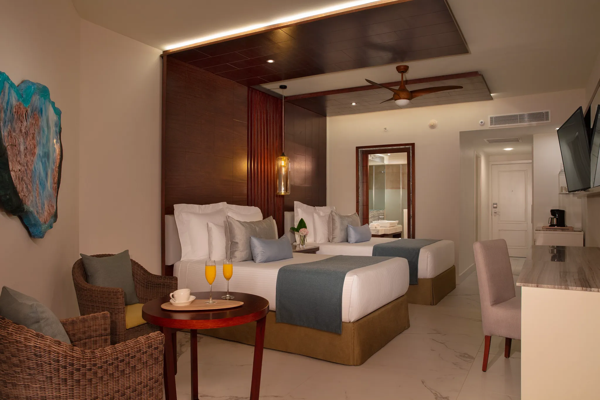Junior Suite with two double beds and seating area at Secrets Royal Beach Punta Cana.