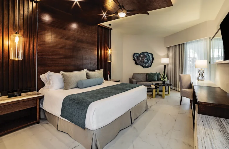 Junior Suite with king bed and modern seating area at Secrets Royal Beach Punta Cana resort.