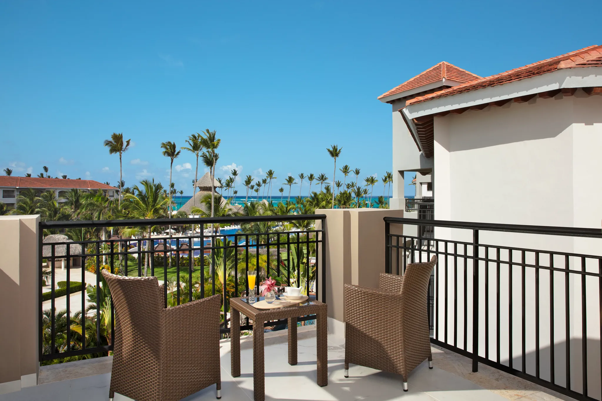 Junior Suite Partial Ocean View balcony with tropical resort and ocean views at Secrets Royal Beach Punta Cana.