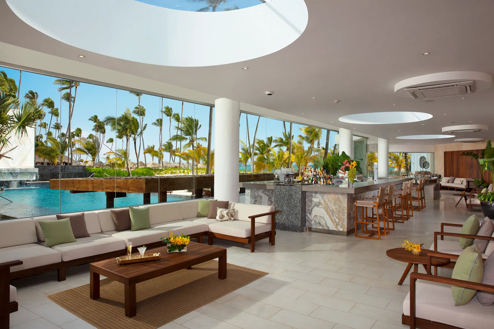 Preferred Club Bar at Secrets Royal Beach Punta Cana featuring an elegant lounge with marble bar, modern seating, and tropical views.