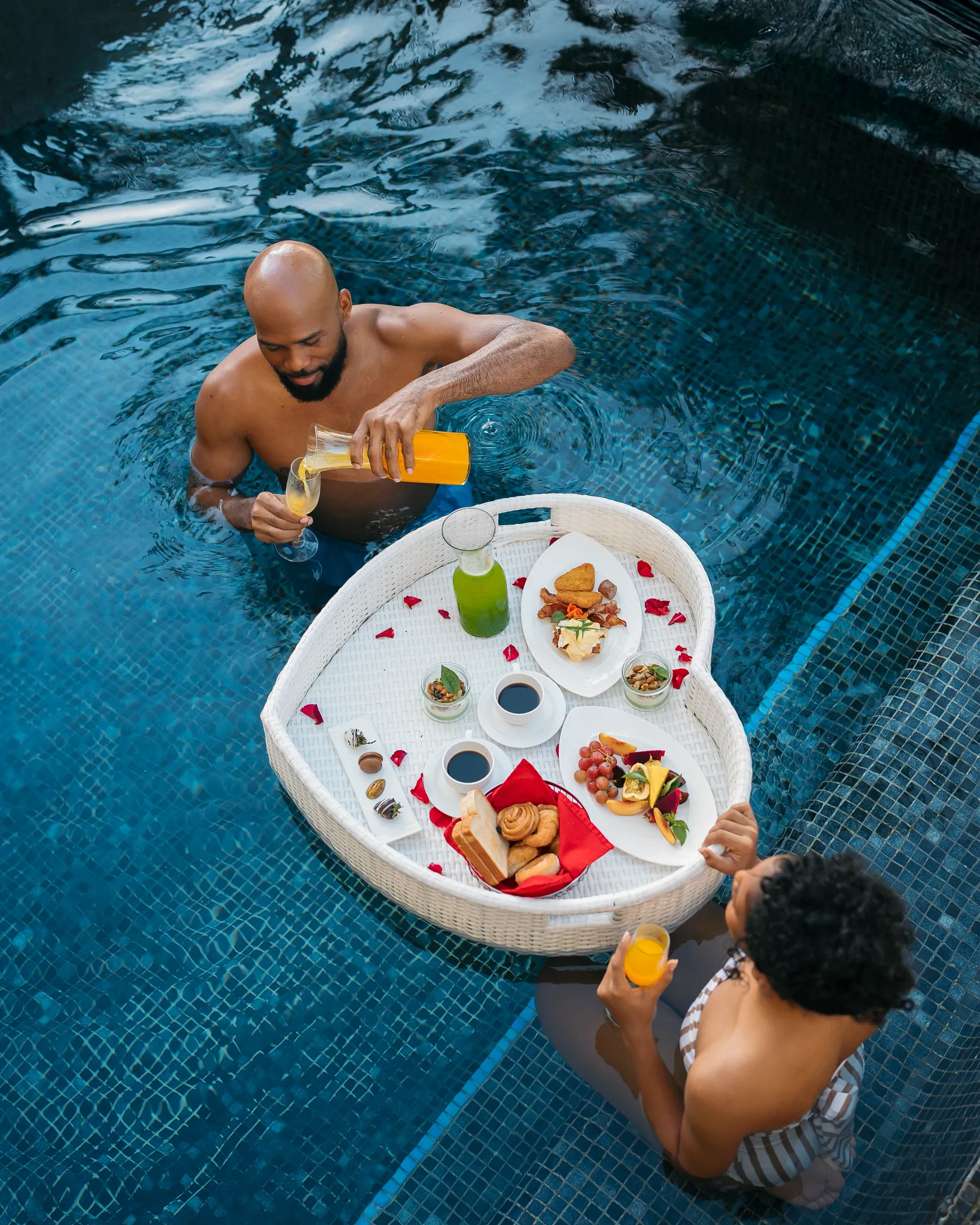 Couple enjoying a floating breakfast tray in a private pool at Secrets Royal Beach Punta Cana.
