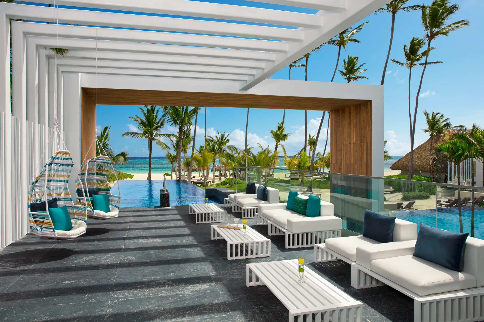 Ocean-view infinity pool solarium lounge with modern seating at Secrets Royal Beach Punta Cana.