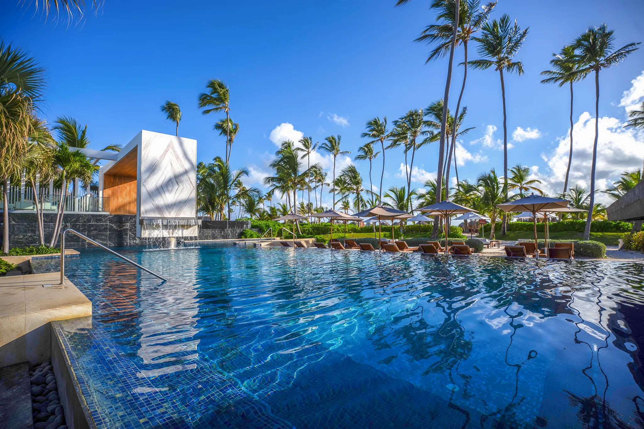 Infinity pool surrounded by palm trees at Secrets Royal Beach Punta Cana, offering a luxurious adults-only pool experience near the Caribbean beach.