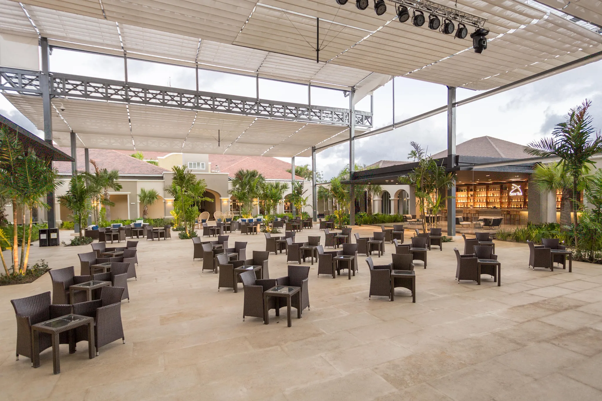 Open-air main plaza with seating and bar area at Secrets Royal Beach Punta Cana resort in the Dominican Republic.